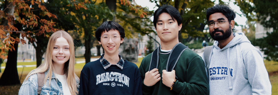 Four international Western students stand on campus in the fall