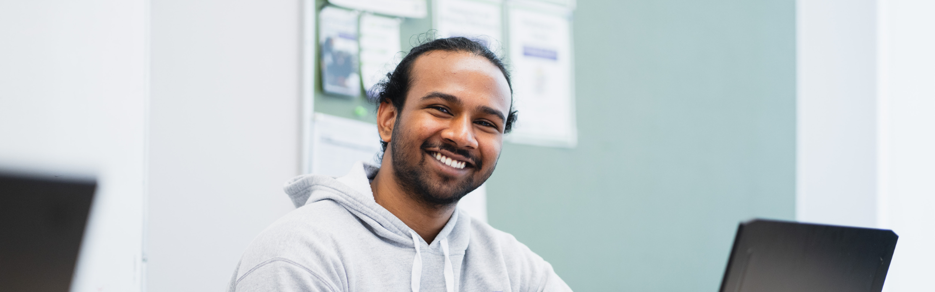 A young man sits in a modern style office.