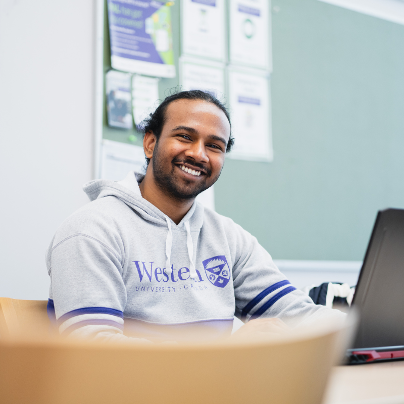 A young man sits in a modern style office.