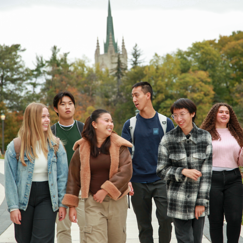 Students looking at a white board, with one student actively writing.